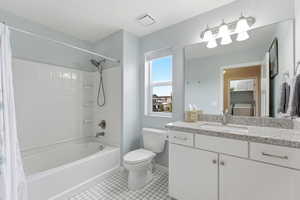 Full bath featuring vanity, washer / clothes dryer, shower / bath combo, and light tile patterned floors