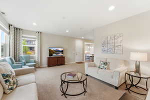 Living area with recessed lighting and light colored carpet