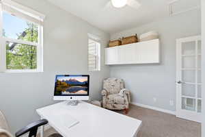 Office area with light carpet and a ceiling fan