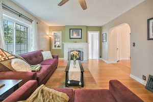 Living room with arched walkways, hardwood flooring