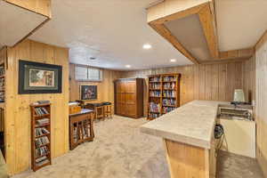Office area featuring wooden walls, light colored carpet, and recessed lighting