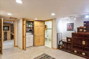 Living area featuring track lighting and washer and dryer