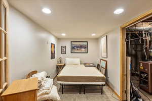 Bedroom with a heating unit and recessed lighting