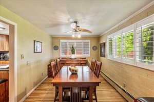 Dining area with baseboard heating, light wood-style flooring, and a ceiling fan