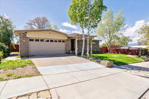 Ranch-style home featuring a garage, driveway, and brick siding