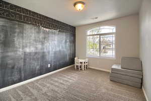 Living area featuring an accent wall and carpet floors