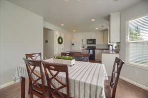 Dining room with recessed lighting and dark wood-style flooring