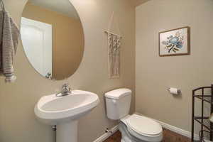 Half bathroom with dark wood-type flooring