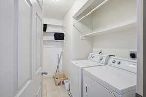 Laundry room featuring separate washer and dryer and light tile patterned floors