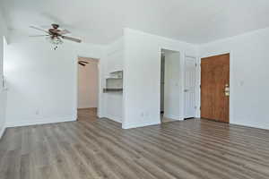 Unfurnished living room with light wood finished floors and a ceiling fan