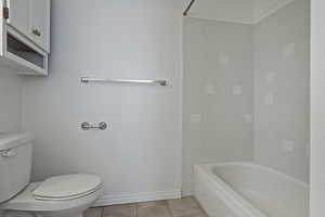 Bathroom with light tile patterned floors and  shower combination
