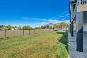 Fenced backyard with a mountain view and a patio area