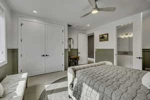 Carpeted bedroom featuring a wainscoted wall, a closet, recessed lighting, and a ceiling fan