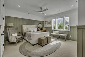 Carpeted bedroom featuring wainscoting, ceiling fan, recessed lighting, and a decorative wall
