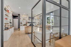 Wine cellar with light wood-type flooring and recessed lighting