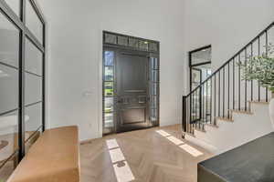 Entryway featuring parquet flooring and a high ceiling