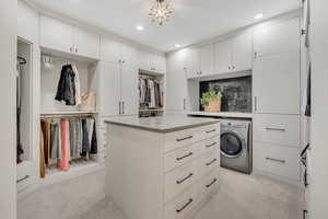 Walk in closet featuring washer / clothes dryer and light colored carpet