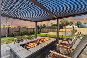 Patio terrace at dusk with a pergola, a patio, and a fenced backyard
