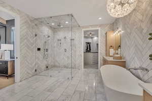 Bathroom featuring vanity, a freestanding bath, a spacious closet, and a stall shower