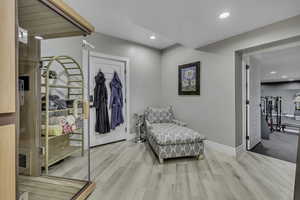 Sitting room featuring a relaxing sauna, recessed lighting, and light wood-style flooring