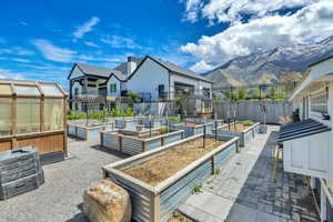 View of patio / terrace with a greenhouse, an outbuilding, a garden, and a sunroom