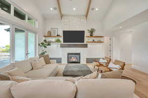 Living area with a fireplace, light wood-style floors, and recessed lighting