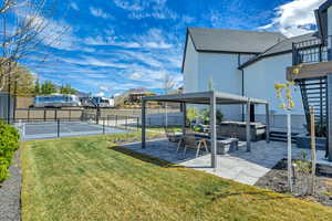 Fenced backyard featuring a hot tub, a patio, basketball hoop, and a residential view