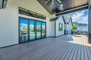 Wooden deck featuring a mountain view and a ceiling fan