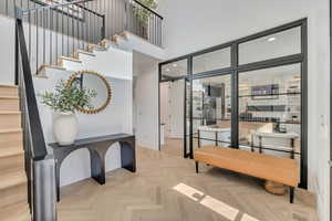 Entrance foyer with parquet flooring, recessed lighting, and a high ceiling