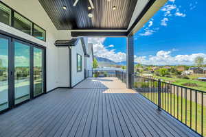 Wooden deck with a mountain view, a yard, and a residential view
