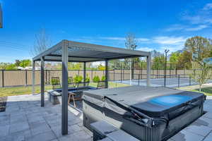 View of patio / terrace with a hot tub and an outdoor fire pit