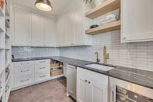 Kitchen with open shelves, wine cooler, white cabinets, and dark stone countertops