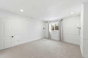 Empty room with light colored carpet, recessed lighting, and crown molding