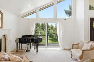 Sitting room featuring a fireplace and lofted ceiling