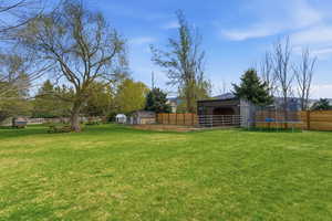 View of yard with an horse stall, a trampoline, and a pole building