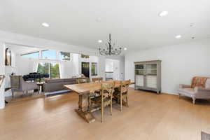 Dining space with light wood-type flooring, a fireplace, and suspended lighting