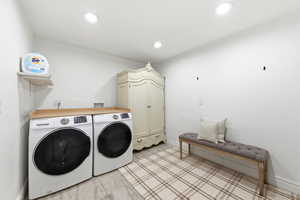 Laundry area with washer and dryer and recessed lighting