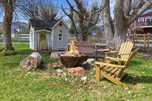 View of yard with an outdoor fire pit and an outbuilding