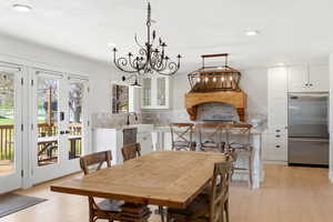 Dining space with light wood finished floors and a chandelier