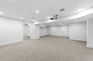 Finished below grade area with light carpet and recessed lighting