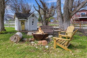 View of yard with an outdoor fire pit and an outbuilding