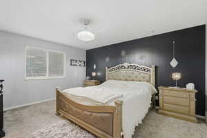 Bedroom with an accent wall and carpet