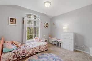 Bedroom featuring vaulted ceiling and light carpet