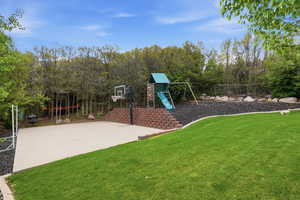 View of basketball court with a playground and basketball hoop