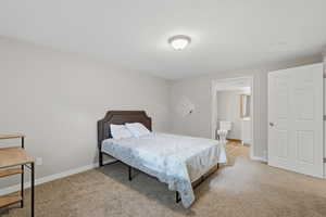Bedroom featuring connected bathroom and light carpet