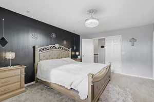 Bedroom featuring light colored carpet and baseboards