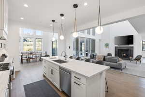 Kitchen featuring a breakfast bar area, white cabinetry, light wood finished floors, open floor plan, and light stone countertops