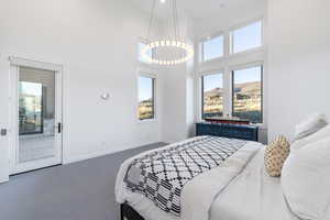 Bedroom with a high ceiling, dark colored carpet, and access to exterior
