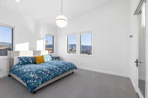 Carpeted bedroom with baseboards and a mountain view