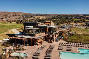 Rear view of house with a patio area, a community pool, a mountain view, and a balcony